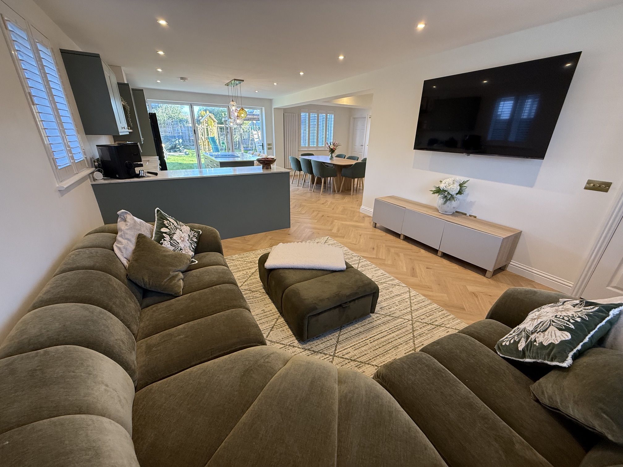 Living area with sofa and wall-mounted TV in the open-plan space