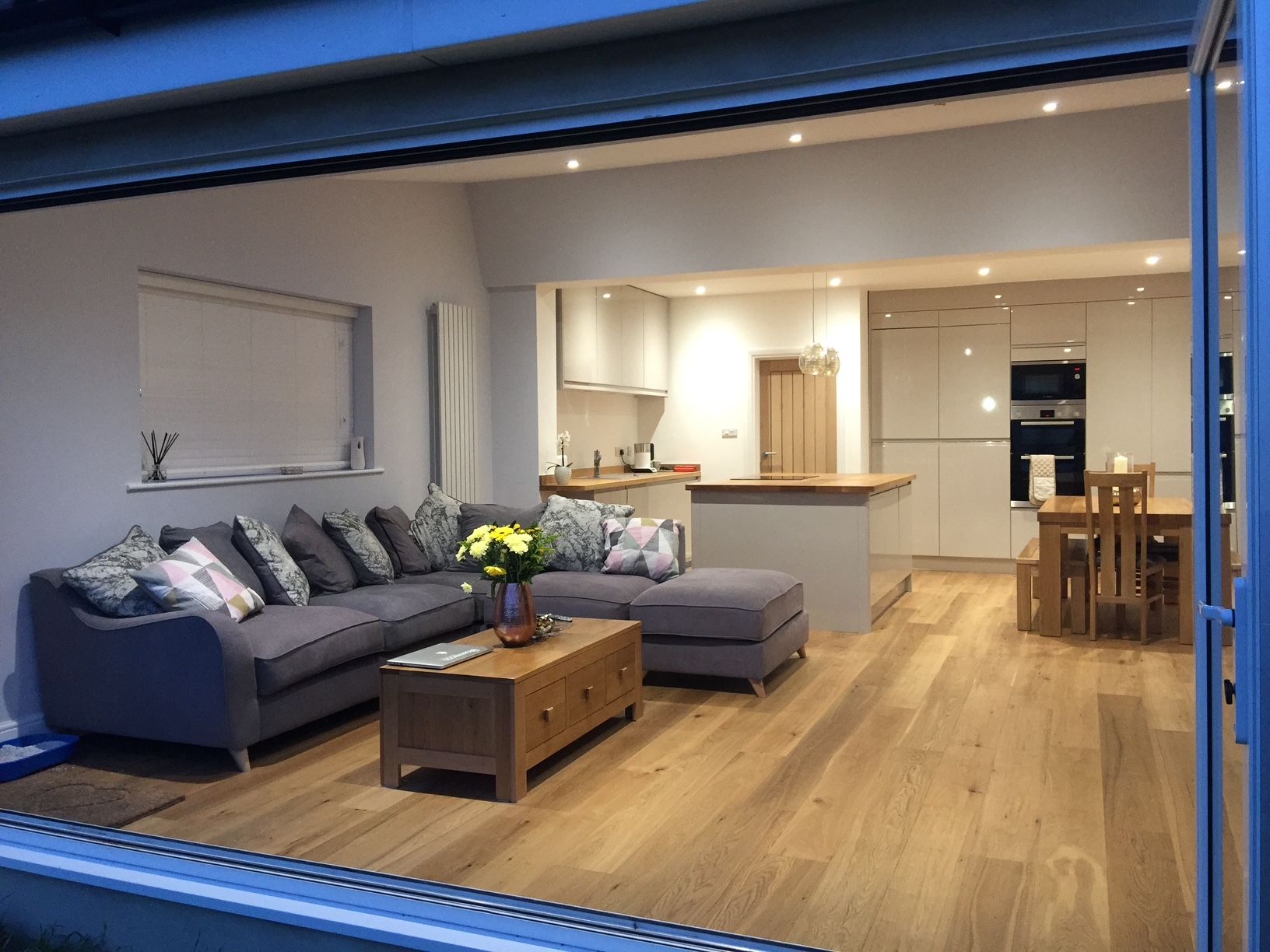 Open-plan extension with oak floor and kitchen island, bifold doors open