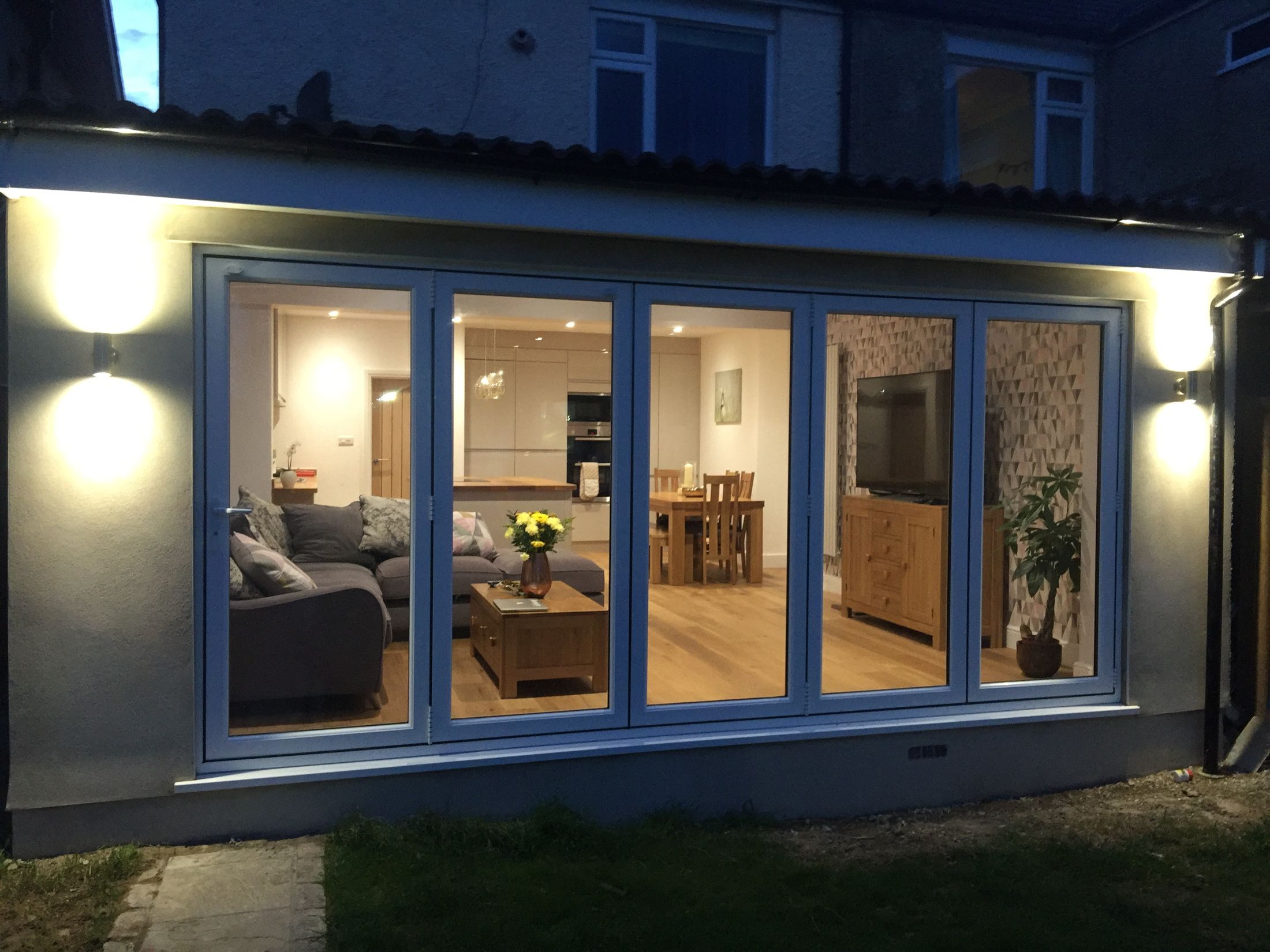 Back of the St Andrews house after: new rear extension with full-width bifold doors lit at dusk